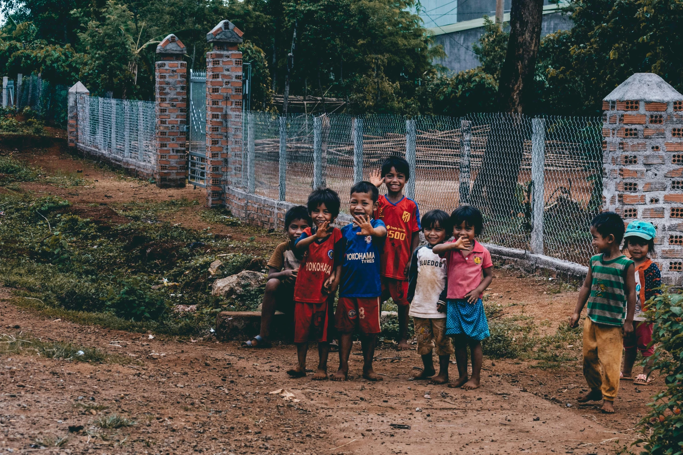 some children pose together for the camera on a dirt road