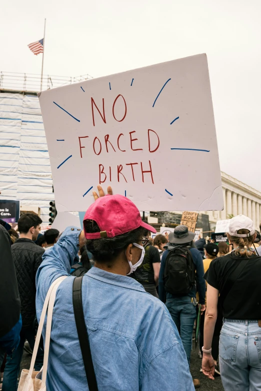 a crowd of people holding signs protesting on a street