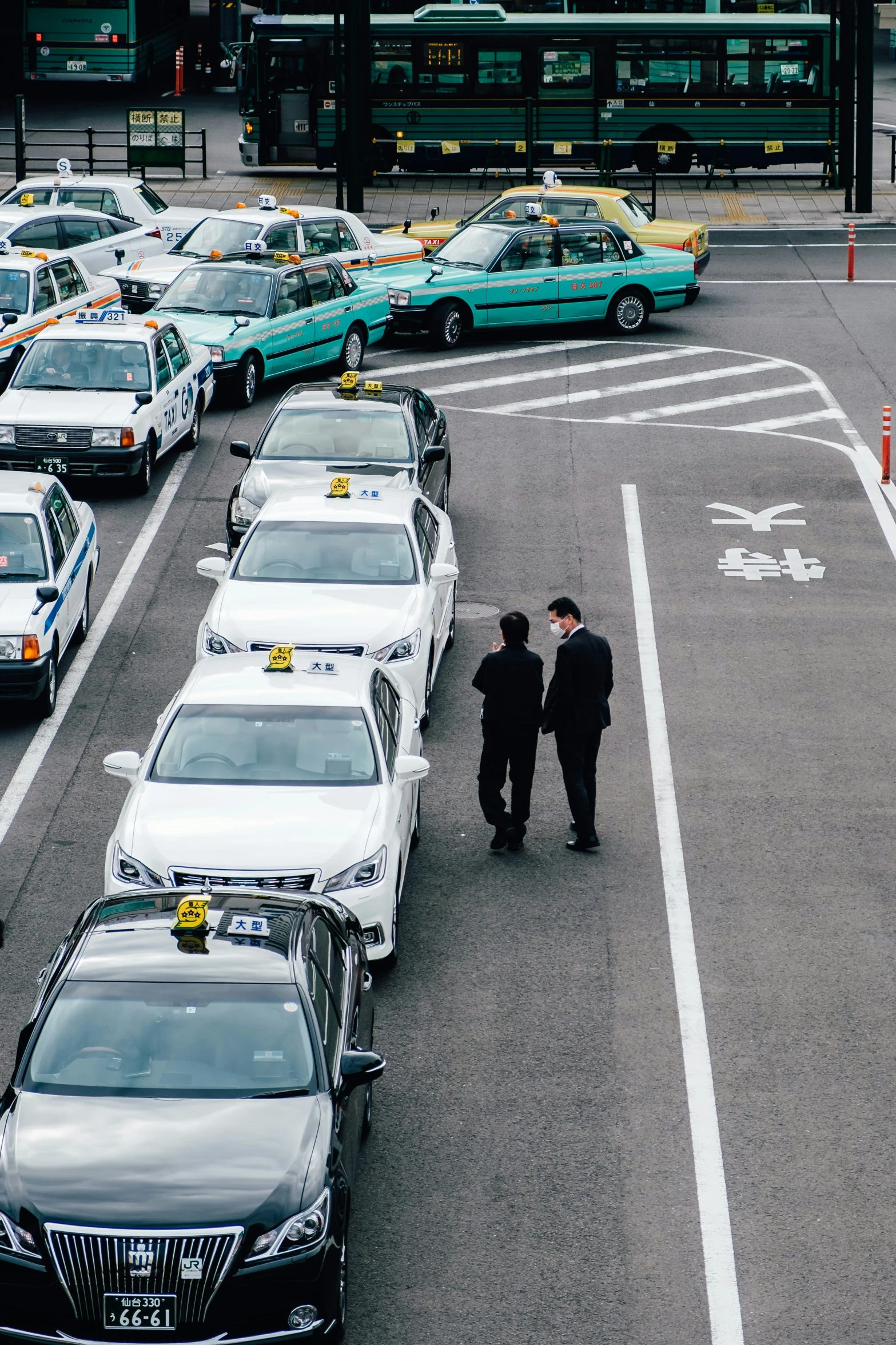 two businessmen in the parking lot surrounded by parked cars