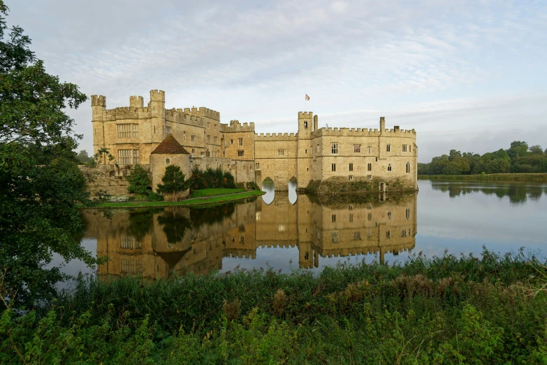 an old castle overlooks a lake in a wooded area