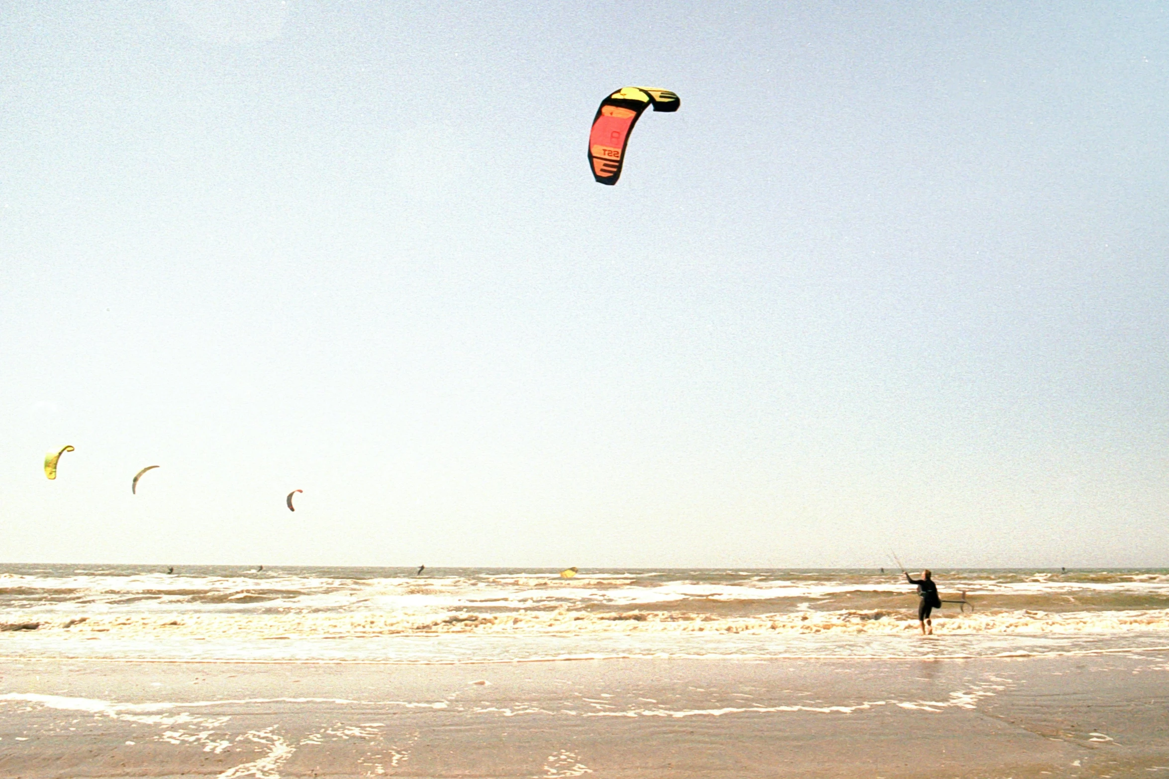 a person kite surfing on the beach and the tide