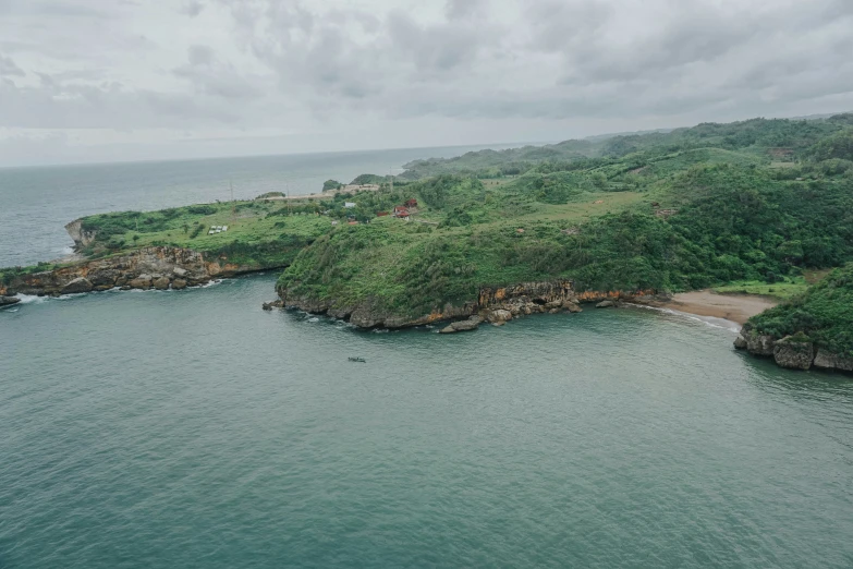 an aerial view of a lush green hillside next to the ocean