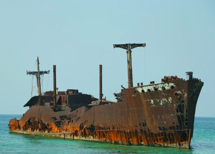 an old ship in the ocean with rusty paint