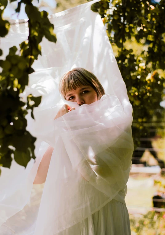 a woman in a white dress with a shawl wrapped around her