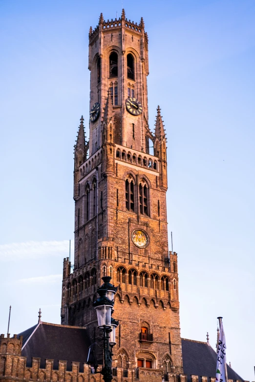 tall stone church tower with two clocks on it