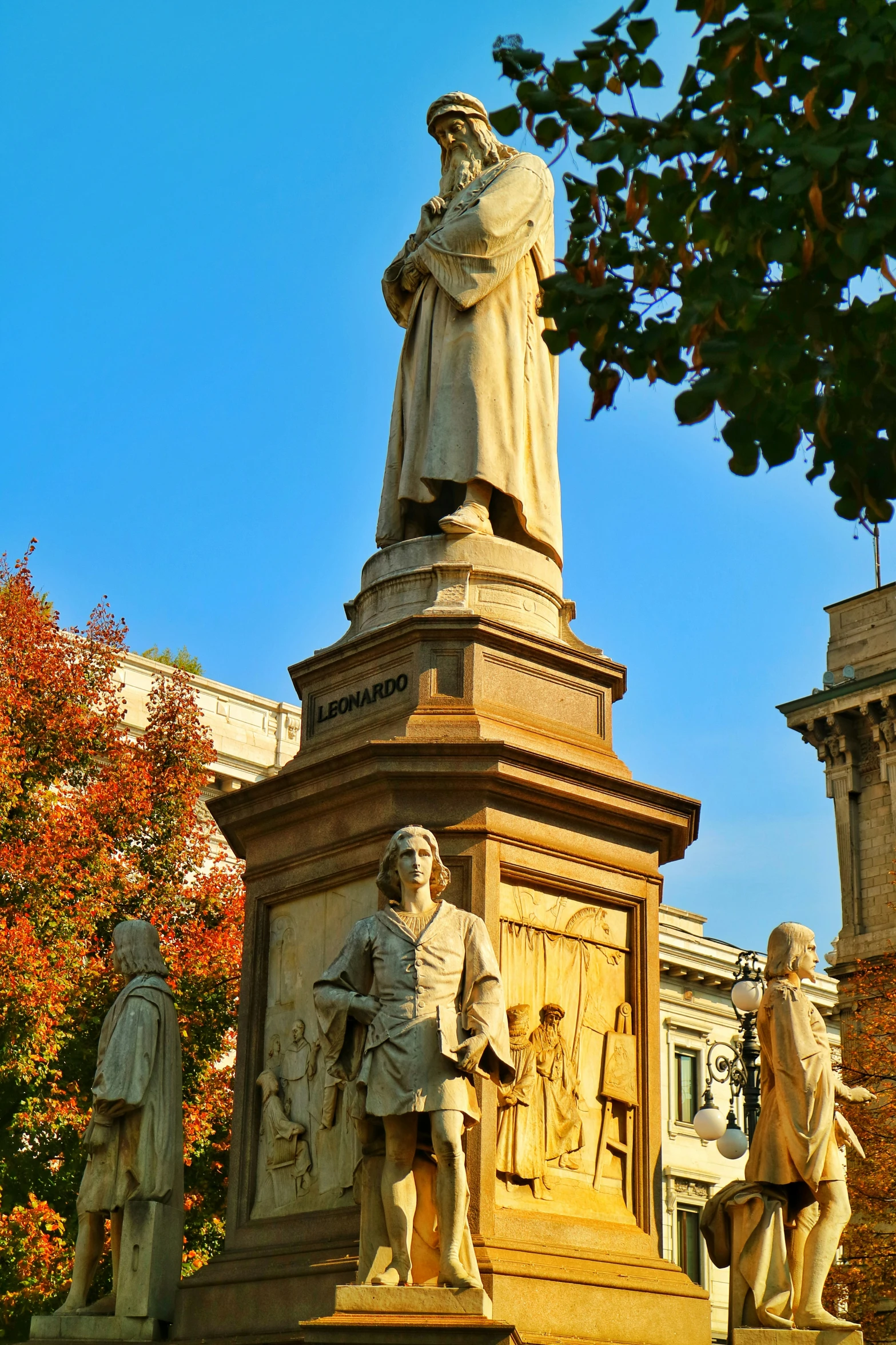 a statue stands surrounded by other statues and trees