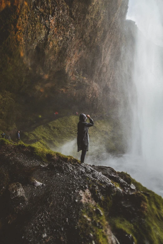 a person takes a po on a hill next to a waterfall