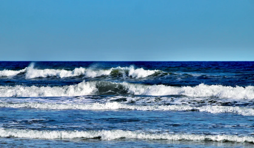 some rough ocean water waves in the distance