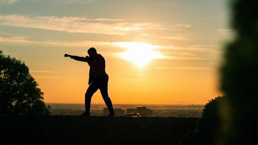 a person standing in front of a sunset