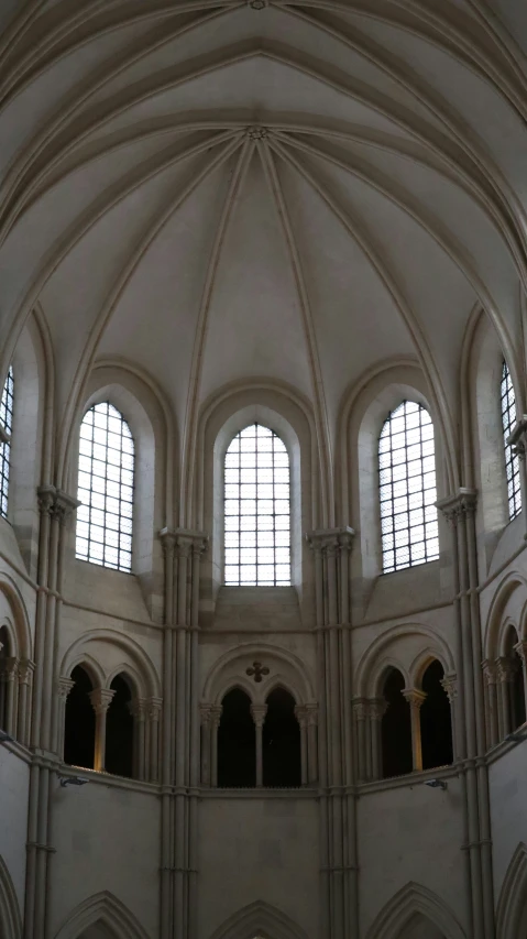 a man standing inside of a church next to stained glass windows