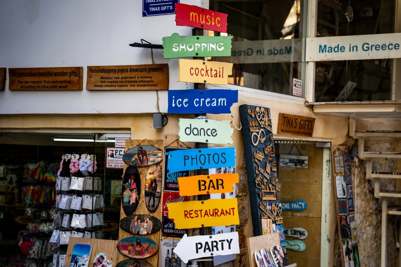 a sign in front of the store is covered with postcards and other signs