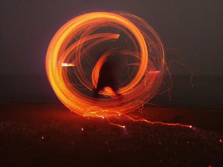 a person is spinning fire into a circular shape