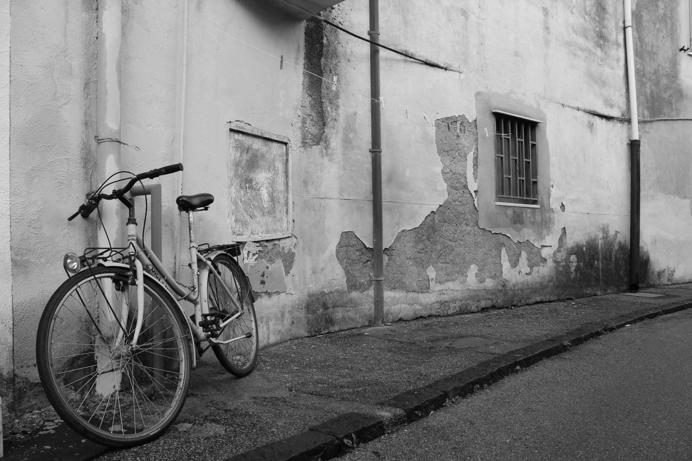 a bike parked outside an old building, on the sidewalk