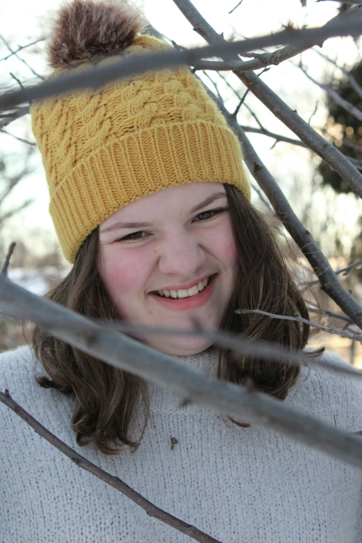 a girl with a yellow hat smiles while posing