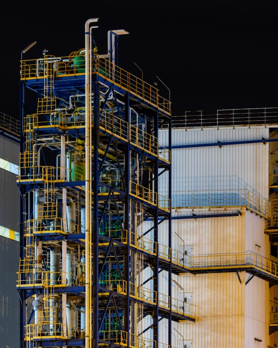 a large industrial plant with some yellow and blue pipes