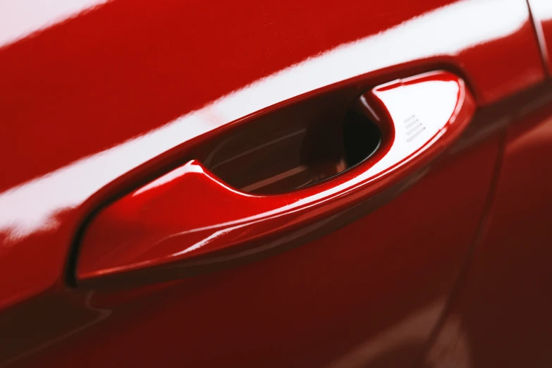 the door handle of a red car with a light on