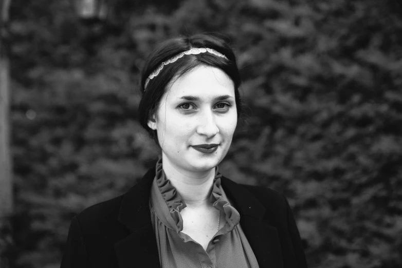 a woman smiling for the camera and wearing a scarf