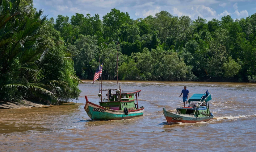 two boats in the water with some people on them