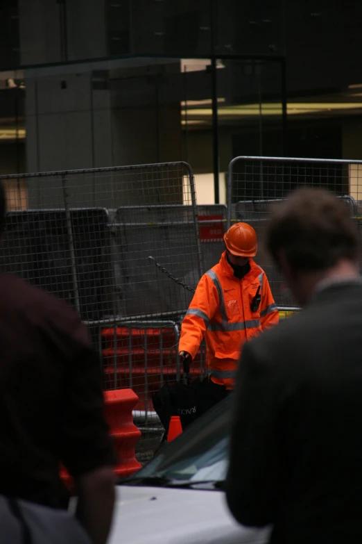 a worker walks past a parked car in a construction area