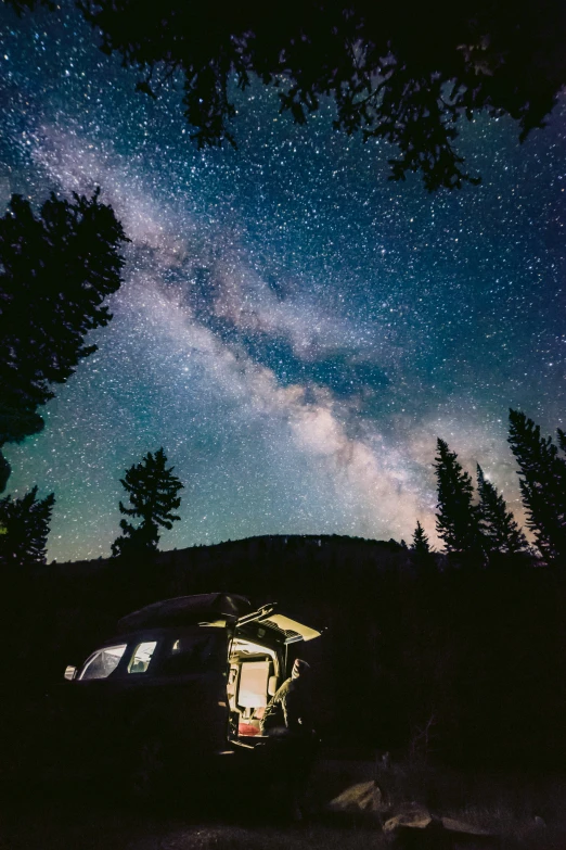 a car is parked in front of trees on the night sky