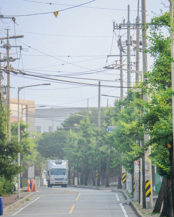 truck driving down a city street surrounded by power lines