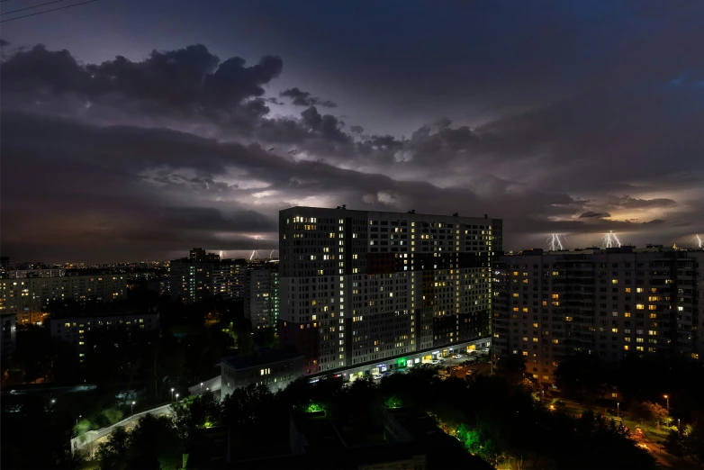 a night scene with many lights on the buildings and clouds