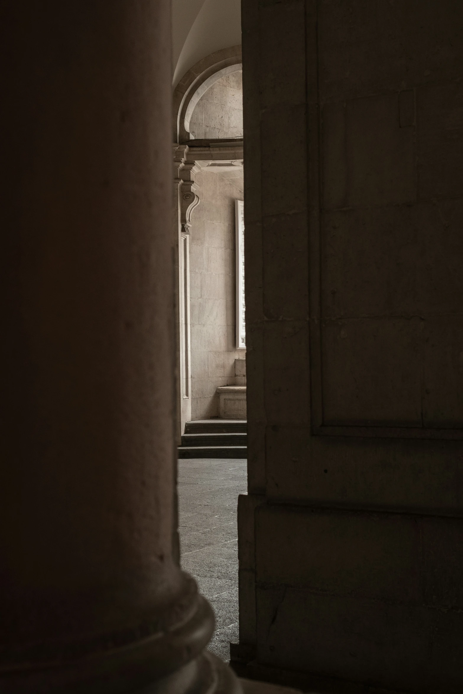 an archway opens to an indoor area with a statue