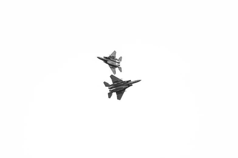 two jets are flying side by side in the sky