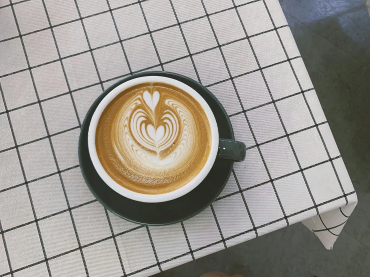 a cappuccino in a black bowl with white swirl