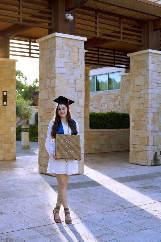 a woman holding a graduate's hat and bag