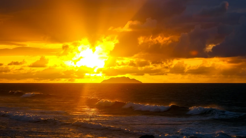 sunset over a ocean with small waves in the water