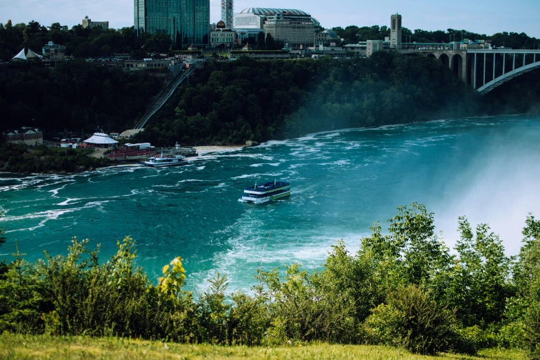 a boat traveling on a river near a bridge