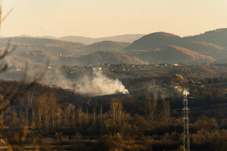 a group of smoke is emitting on top of trees