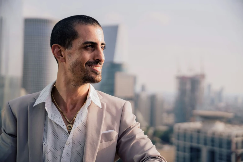 a man wearing a beige jacket sitting on a rooftop