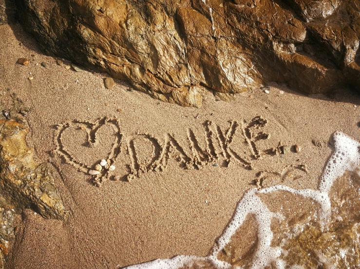 sand drawings on the beach that says sandsawkee