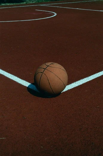 a ball on a red and white court