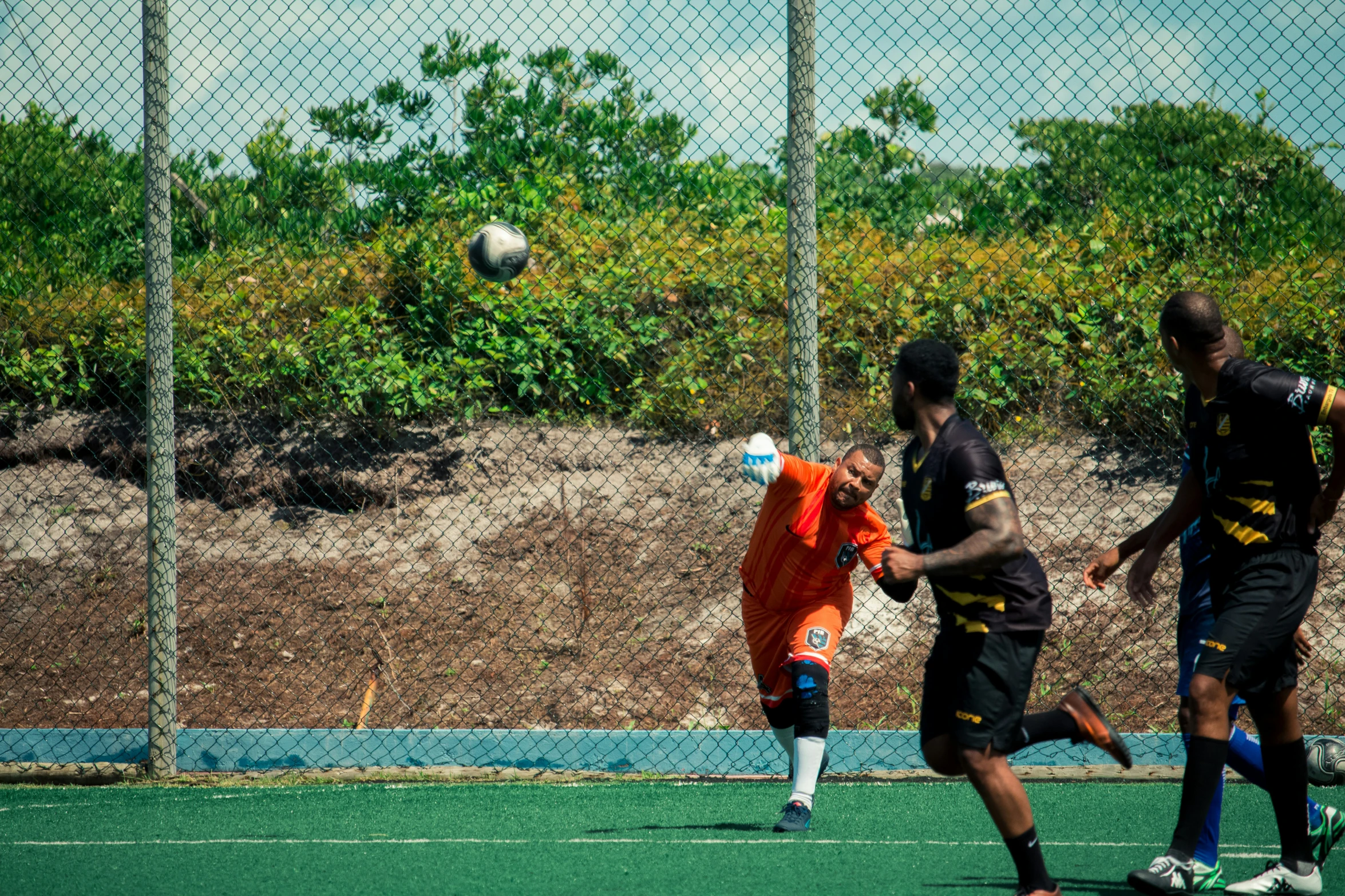 two men are playing soccer in an enclosure