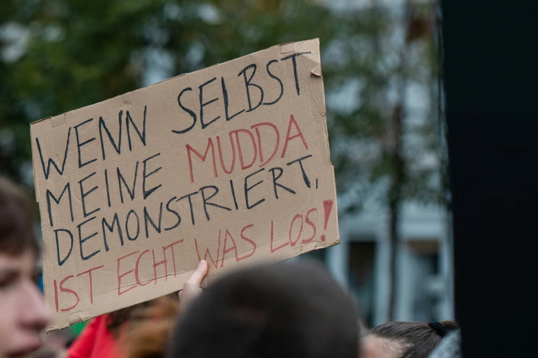 a protest sign in front of a man at an event