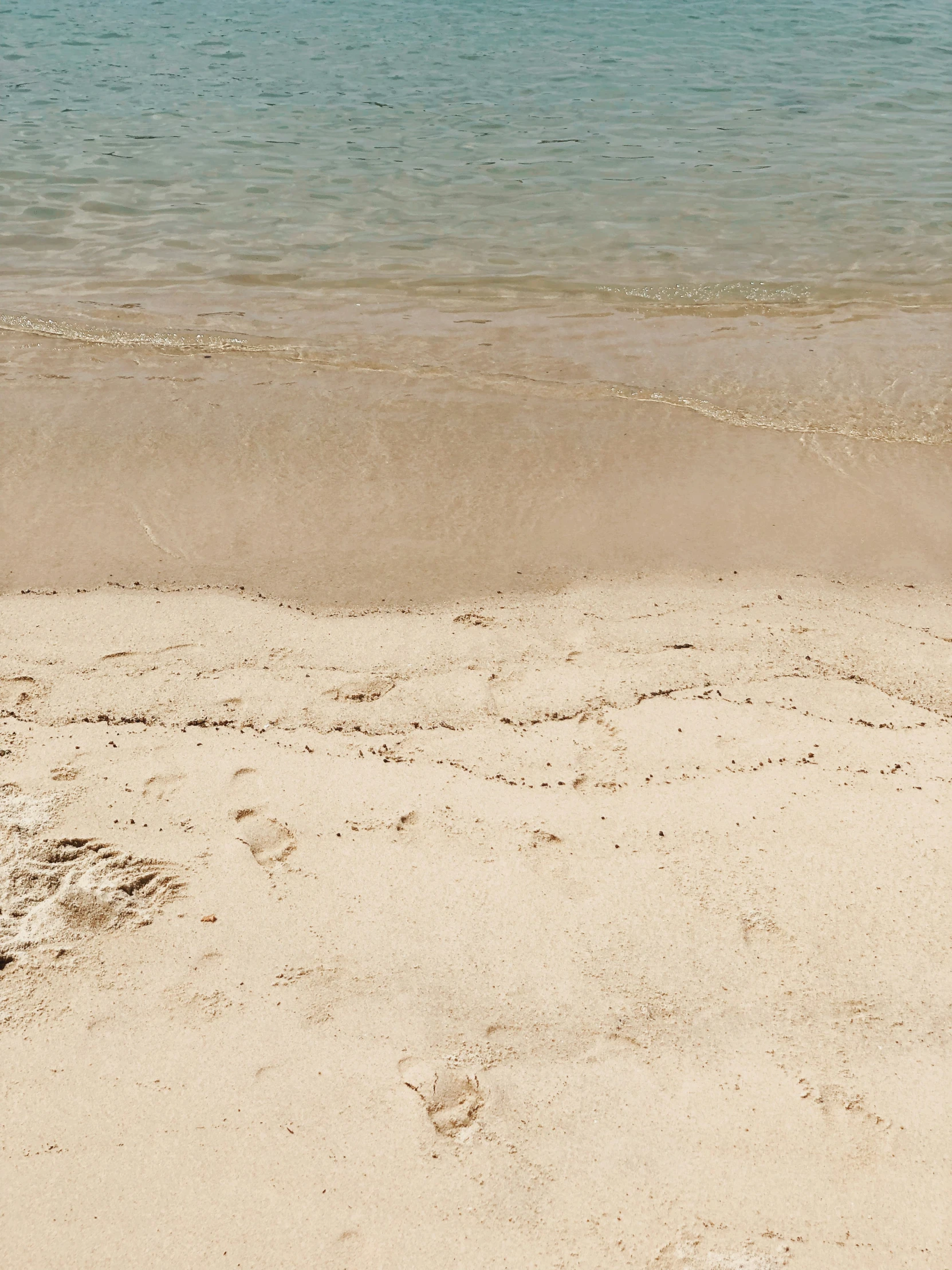 a sandy beach with a boat on the sea