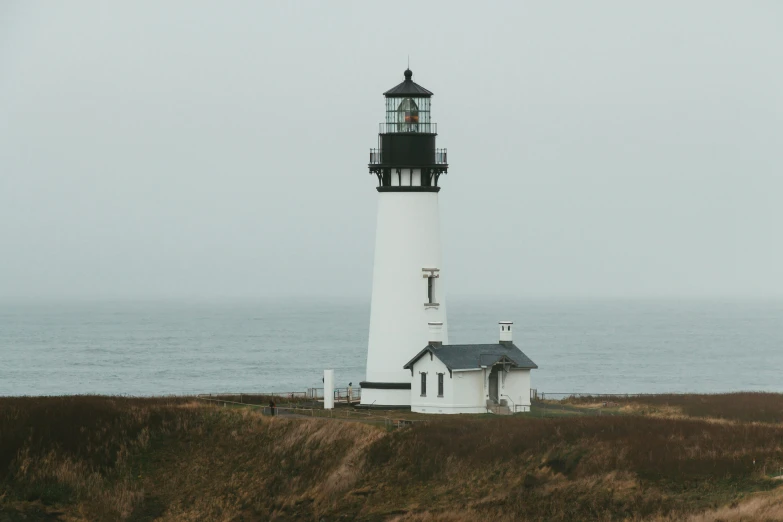 a light house in the middle of a grassy field