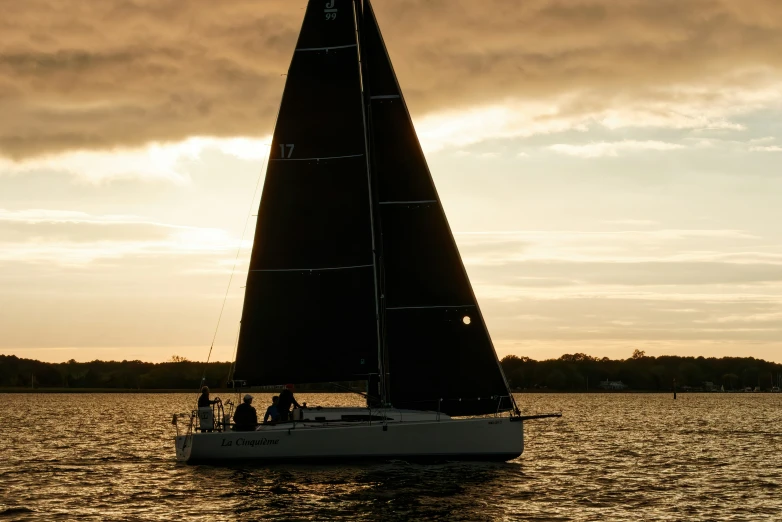 a sailboat sails in front of the sun