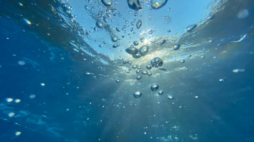 the view from under a blue pool with sun rays