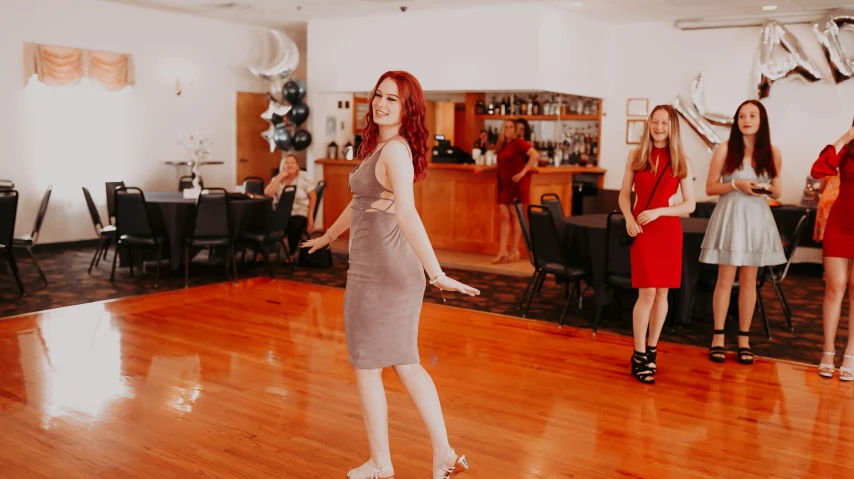 several women in red and silver are standing on the dance floor