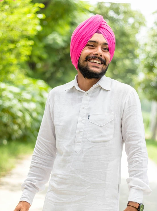 a smiling man with a bright pink hairdo and beard