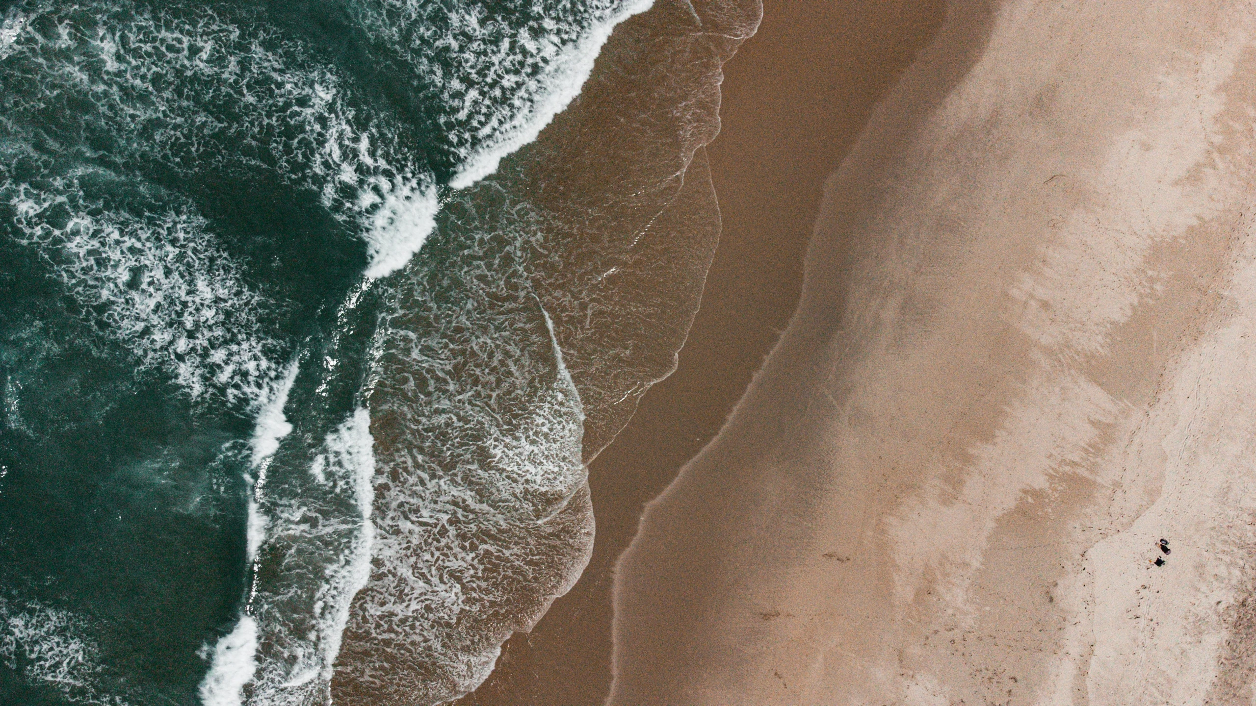 an overhead view of some blue water next to the beach