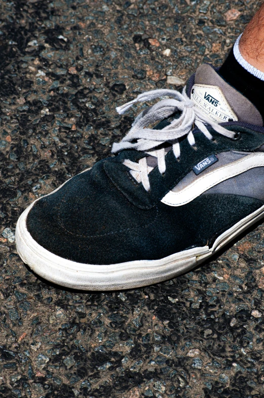 a man wearing white sneakers standing on the street