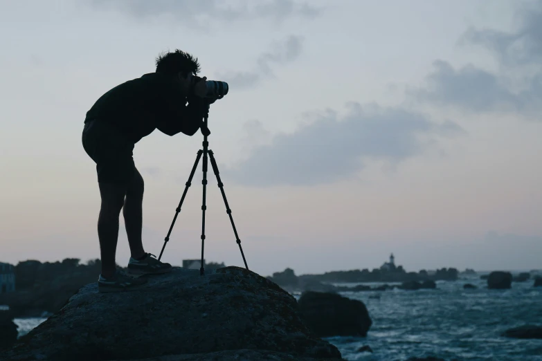 a man that is standing on a rock and taking a po