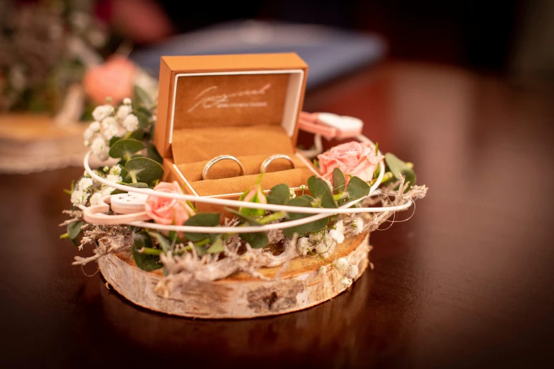 a couple of rings sitting inside of a box with flowers