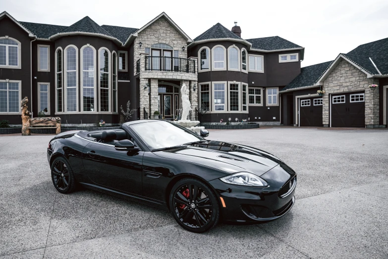 a luxury vehicle parked on the pavement in front of a house