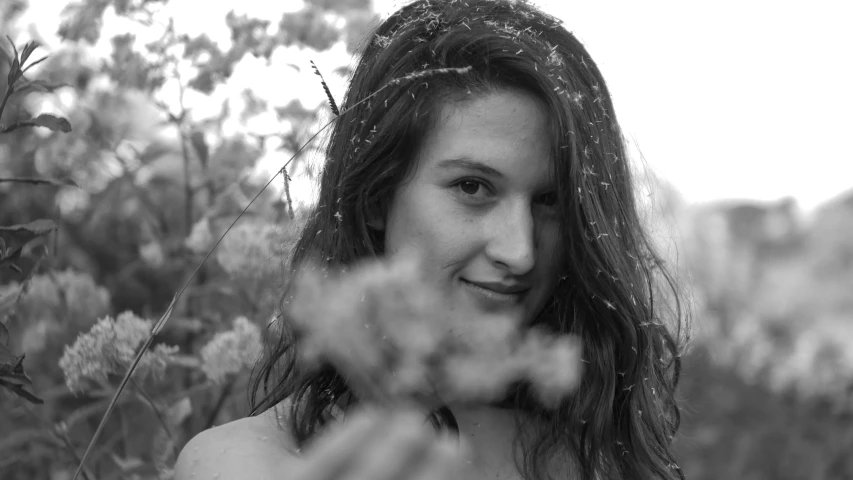 a woman standing in front of some tall grass